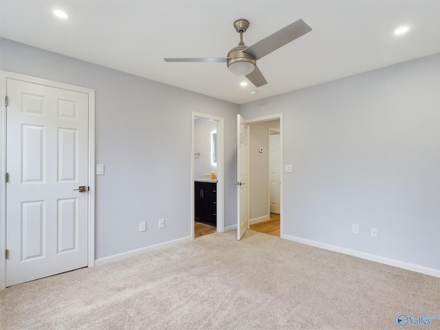 unfurnished bedroom featuring ensuite bath, ceiling fan, and light colored carpet