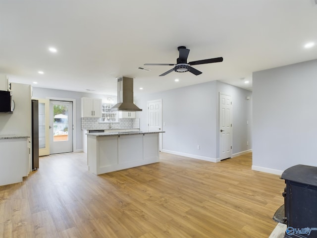 kitchen with island range hood, ceiling fan, white cabinetry, light wood-type flooring, and appliances with stainless steel finishes