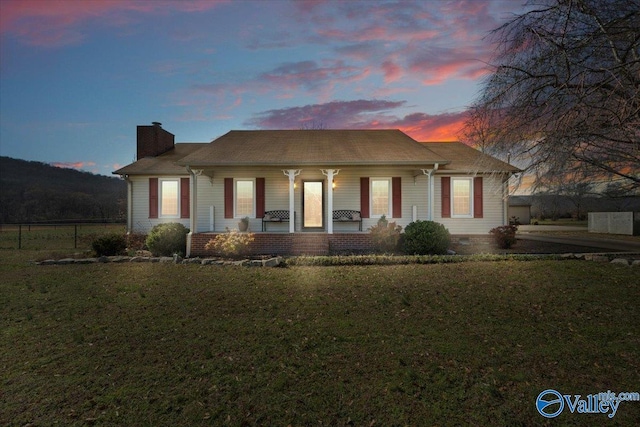 bungalow-style house with a chimney, crawl space, covered porch, fence, and a front lawn