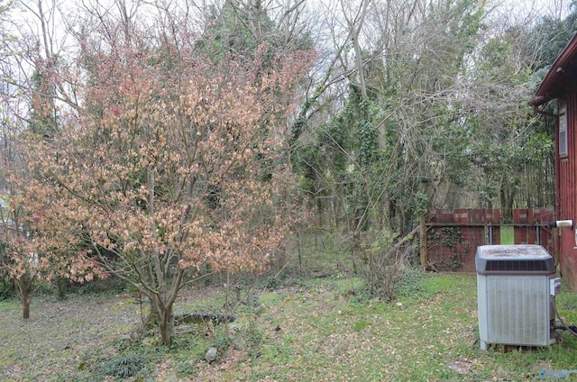 view of yard featuring central air condition unit and fence