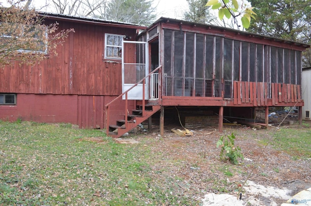 rear view of property with a lawn, metal roof, and a sunroom