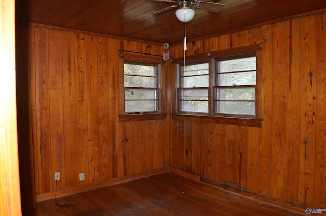 unfurnished room featuring hardwood / wood-style floors, wood walls, wood ceiling, and a ceiling fan