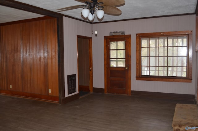 unfurnished living room with heating unit, crown molding, wood finished floors, baseboards, and ceiling fan