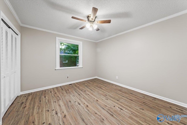 unfurnished bedroom with ceiling fan, crown molding, hardwood / wood-style flooring, a textured ceiling, and a closet