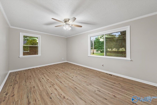 spare room featuring a textured ceiling, crown molding, and light hardwood / wood-style flooring