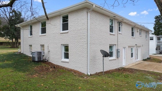 view of property exterior with a lawn and central air condition unit