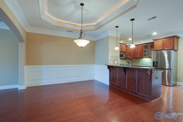 kitchen with hanging light fixtures, a kitchen bar, crown molding, and appliances with stainless steel finishes