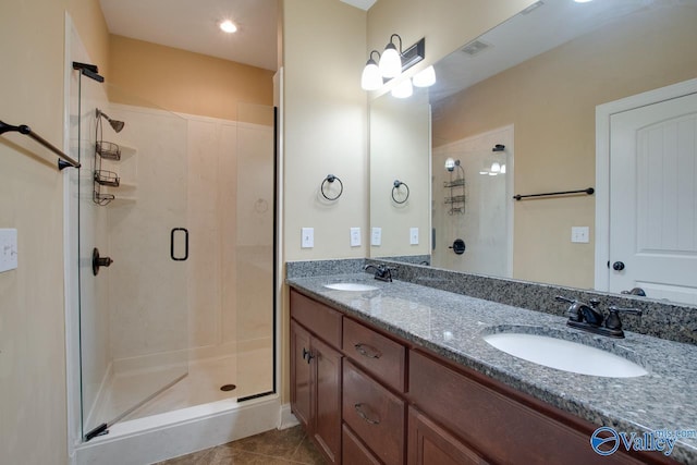 bathroom featuring tile patterned floors, vanity, and a shower with shower door