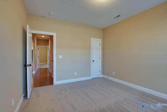 unfurnished bedroom featuring light carpet