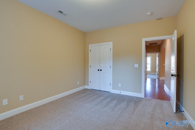 unfurnished bedroom with carpet floors and a closet