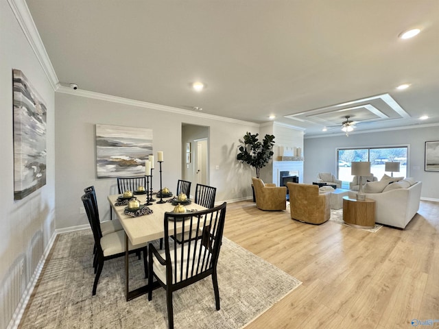 dining space with wood finished floors, baseboards, recessed lighting, a fireplace, and crown molding