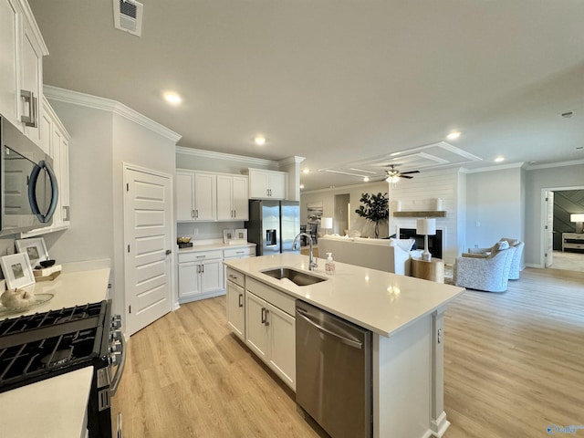 kitchen with visible vents, an island with sink, a sink, appliances with stainless steel finishes, and open floor plan