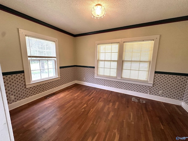 empty room featuring crown molding, wood-type flooring, and a textured ceiling