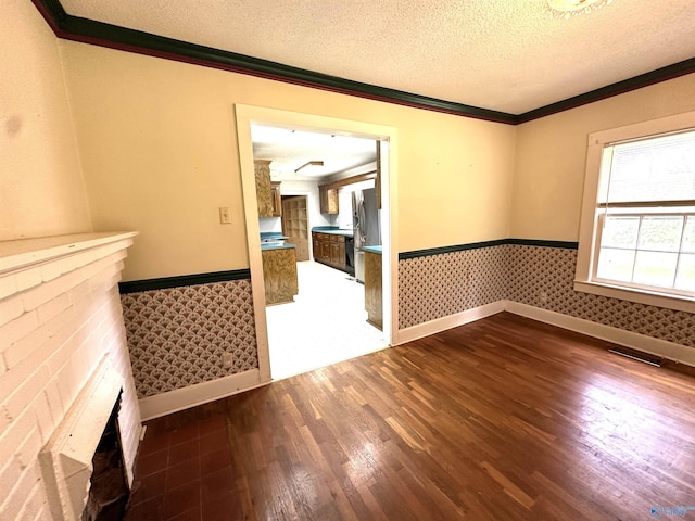 spare room with dark hardwood / wood-style flooring, ornamental molding, and a textured ceiling