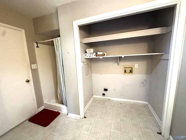 clothes washing area featuring hookup for a washing machine, a textured ceiling, and electric dryer hookup