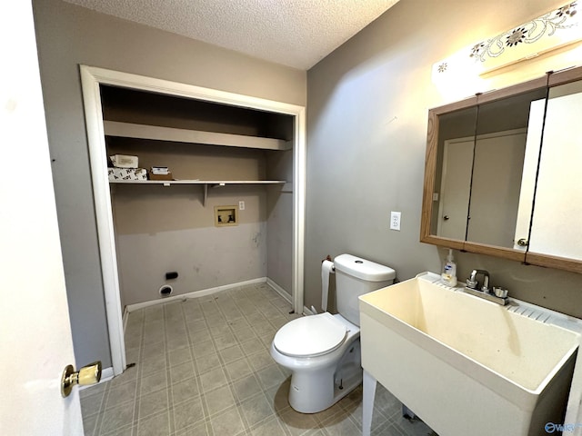 bathroom featuring vanity, toilet, and a textured ceiling