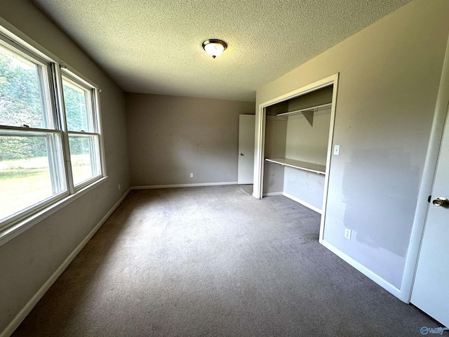 unfurnished bedroom featuring carpet, a textured ceiling, and a closet