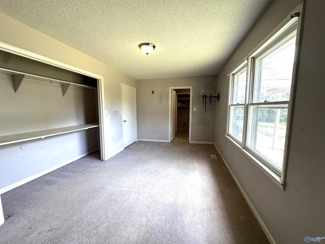 unfurnished bedroom featuring a closet, a textured ceiling, and carpet flooring