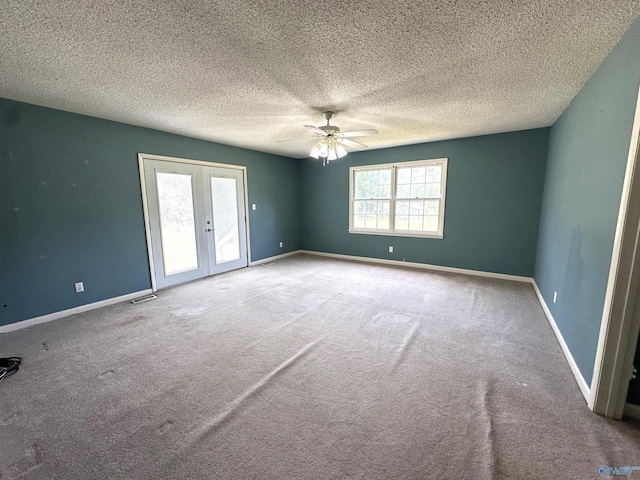 empty room with a textured ceiling, french doors, ceiling fan, and carpet