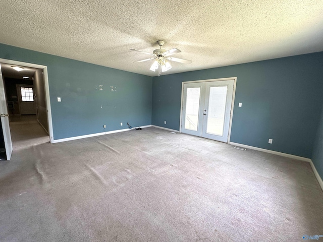 empty room with carpet flooring, a textured ceiling, ceiling fan, and french doors