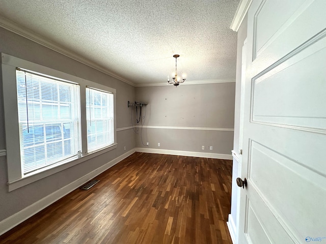 unfurnished dining area featuring ornamental molding, dark wood-type flooring, a textured ceiling, and a chandelier