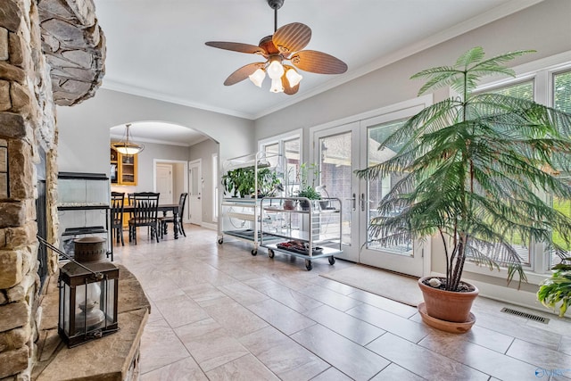 interior space with ceiling fan, tile patterned floors, and crown molding