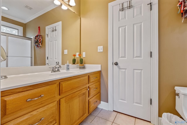 bathroom featuring tile patterned flooring, toilet, ornamental molding, and vanity