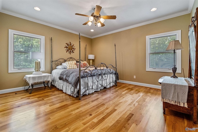 bedroom featuring light hardwood / wood-style flooring, ceiling fan, multiple windows, and ornamental molding