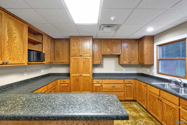 kitchen featuring sink, dark tile patterned flooring, and a paneled ceiling