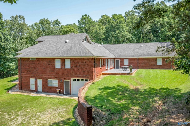 back of property with a patio, a garage, and a yard