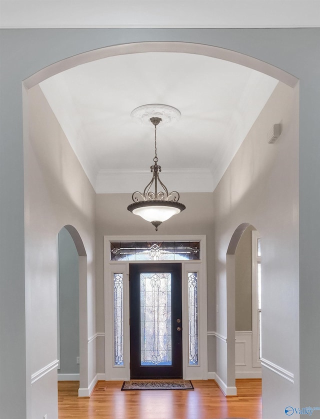 foyer with hardwood / wood-style floors and crown molding