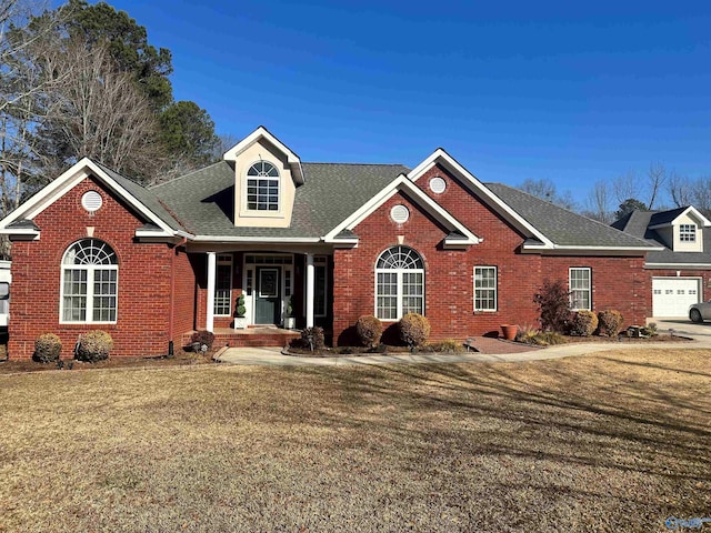 front of property with covered porch, a garage, and a front lawn