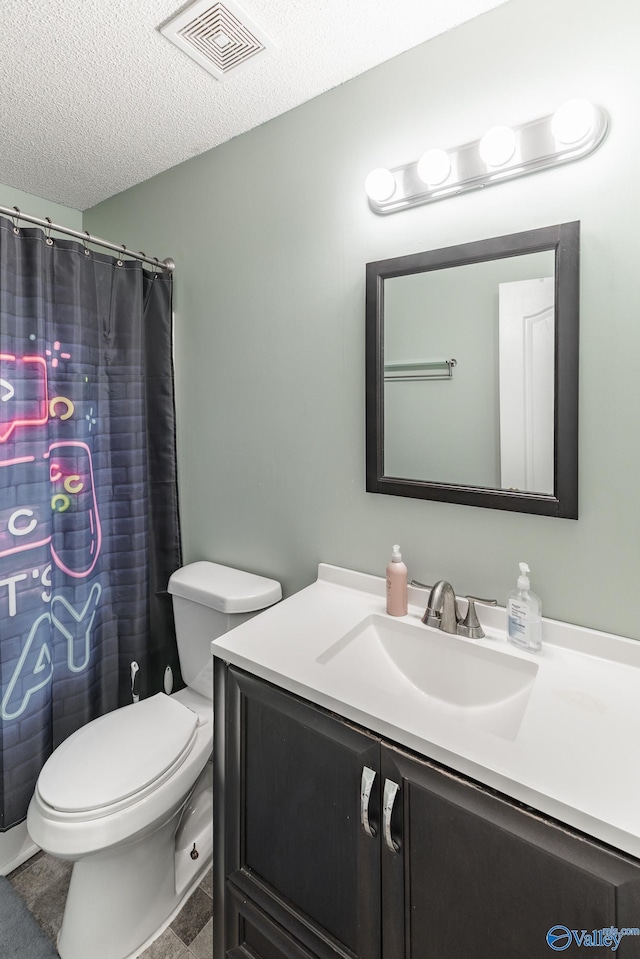 bathroom with vanity, a textured ceiling, and toilet