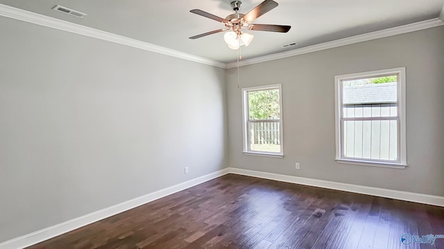 empty room with dark wood-style floors, crown molding, visible vents, and baseboards