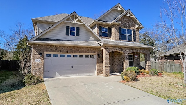 craftsman inspired home with driveway, brick siding, roof with shingles, and fence