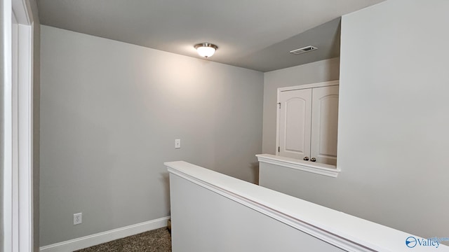 hallway featuring carpet, an upstairs landing, visible vents, and baseboards