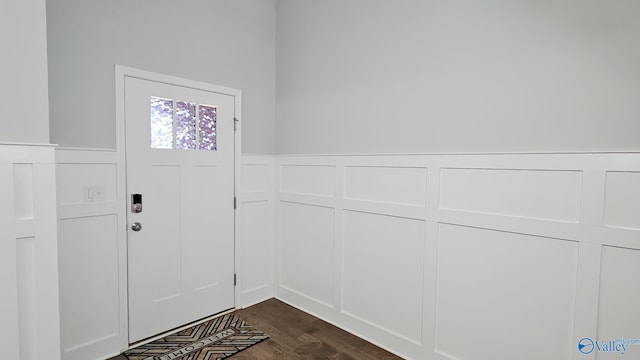 entrance foyer featuring a wainscoted wall, dark wood finished floors, and a decorative wall