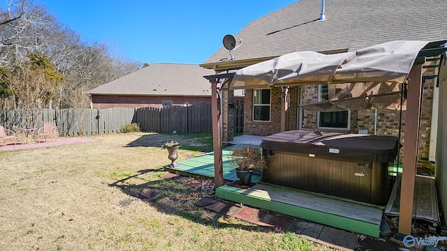 view of yard featuring fence and a hot tub