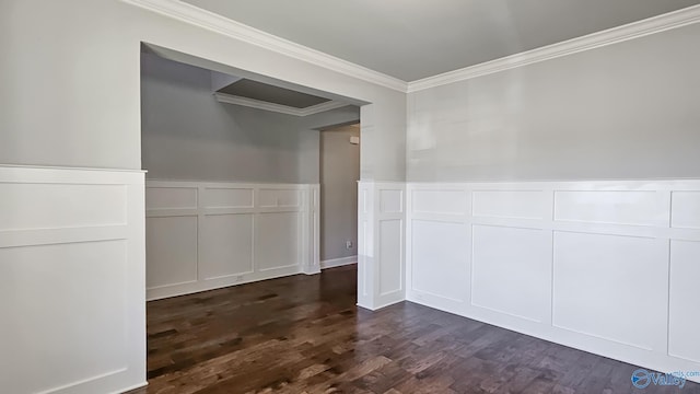 interior space with a wainscoted wall, dark wood finished floors, crown molding, and a decorative wall