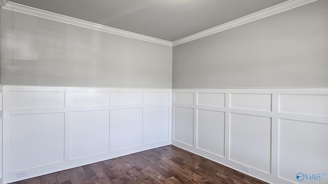 empty room with a wainscoted wall, ornamental molding, dark wood-type flooring, and a decorative wall