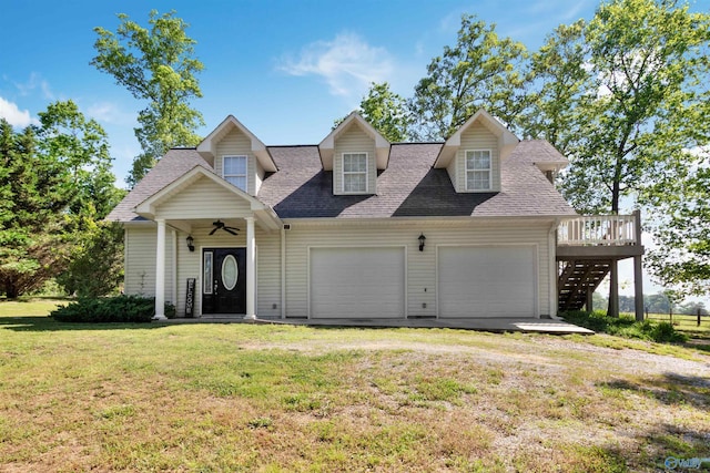 cape cod-style house featuring stairs, a front yard, roof with shingles, and an attached garage