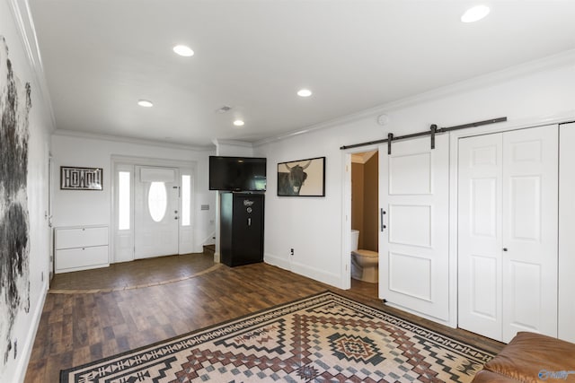 foyer featuring baseboards, ornamental molding, and wood finished floors