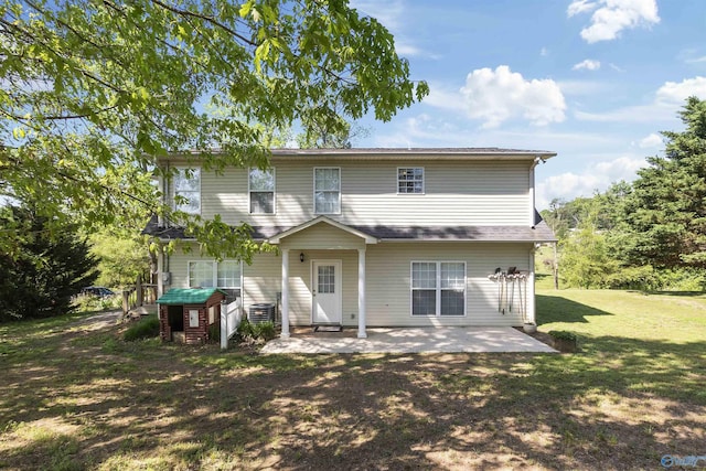 back of house featuring a patio area and a lawn
