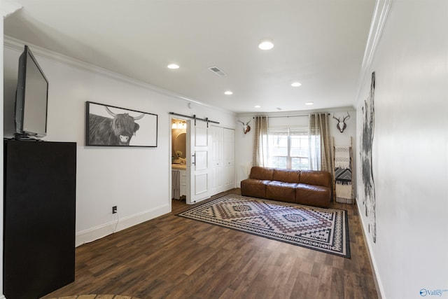 living area with wood finished floors, ornamental molding, a barn door, recessed lighting, and baseboards