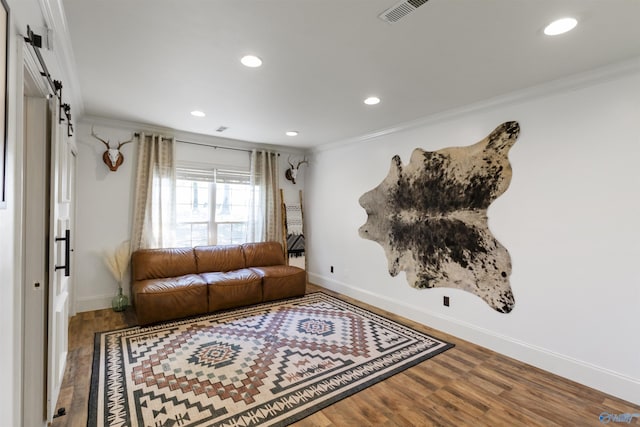 living area featuring recessed lighting, ornamental molding, visible vents, and wood finished floors