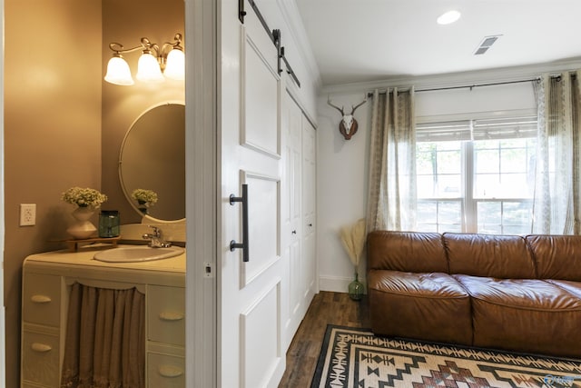 bathroom featuring visible vents, wood finished floors, baseboards, and a sink