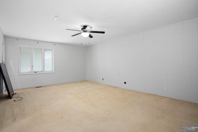 carpeted spare room featuring ceiling fan