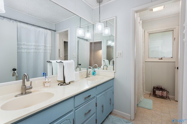 bathroom with double sink vanity, a textured ceiling, and tile patterned floors