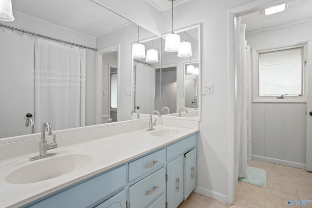 bathroom featuring ornamental molding, vanity, and a textured ceiling