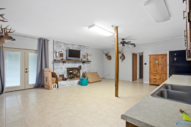 tiled living room with ceiling fan and ornamental molding